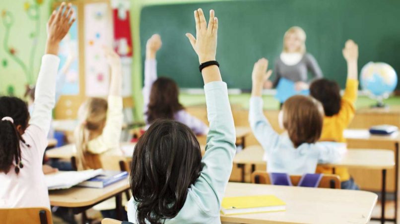 Alumnos levantando la mano en el colegio